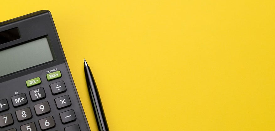 Calculator and pen on yellow background