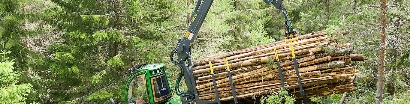 John Deere 1010G is forwarding wood in the forest