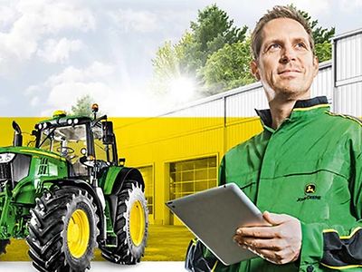 man with a tablet looking away and a Deere tractor in front of a yellow rectangle bar